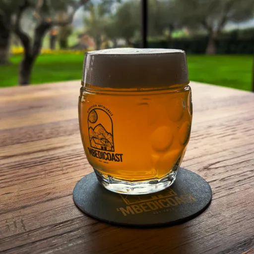 Un bicchiere di birra Helles dorata con schiuma bianca cremosa